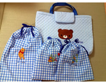 クマの刺しゅうをした手提げカバンと巾着